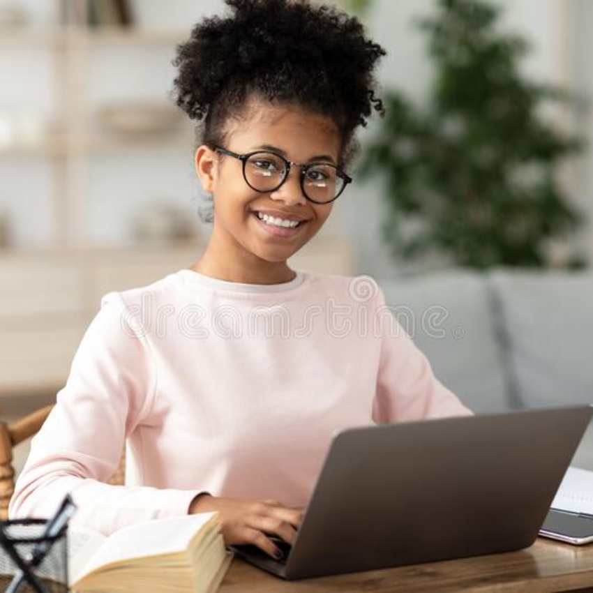black-teen-girl-laptop-learning-online-sitting-home-smiling-to-camera-table-wearing-eyeglasses-distant-school-education-196125818